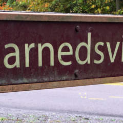 Harnedsville sign on fence
