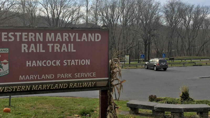 Parking lot with sign for Hancock Station at Western Maryland Rail Trail